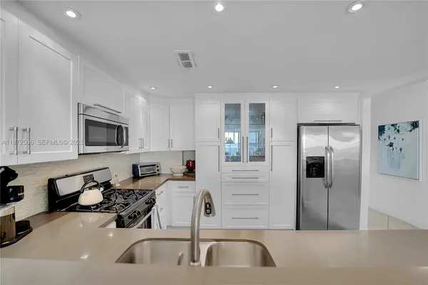 a kitchen with stainless steel appliances a sink a stove and a refrigerator