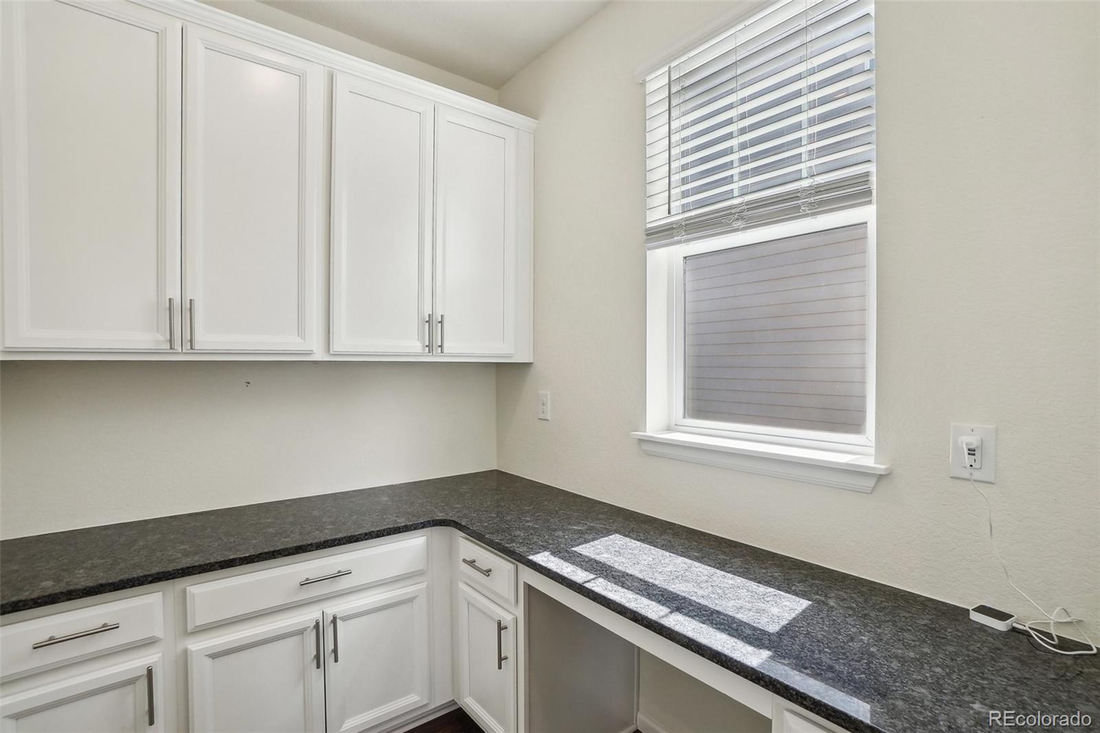 12797 Clearview Street Firestone, CO 80504 - Photo 12 of 44 a kitchen with granite countertop white cabinets and a window