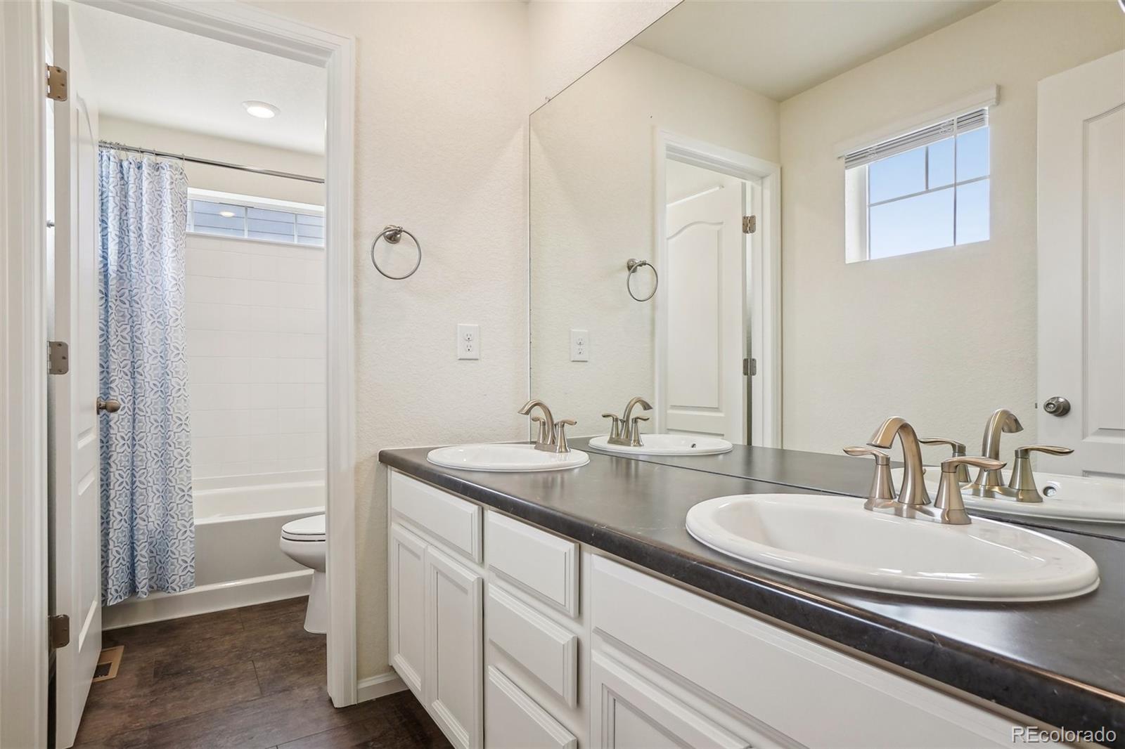 12797 Clearview Street Firestone, CO 80504 - Photo 20 of 44 a bathroom with a granite countertop sink a toilet and a large mirror