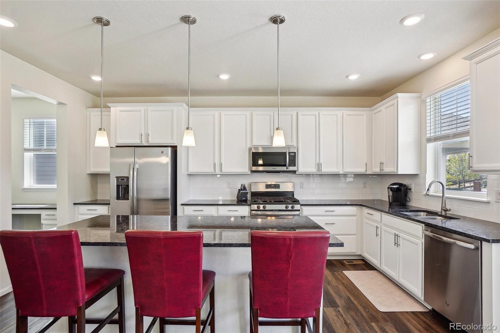 12797 Clearview Street Firestone, CO 80504 - Photo 4 of 44 a kitchen with stainless steel appliances granite countertop a stove a refrigerator a sink a stove a dining table and chairs