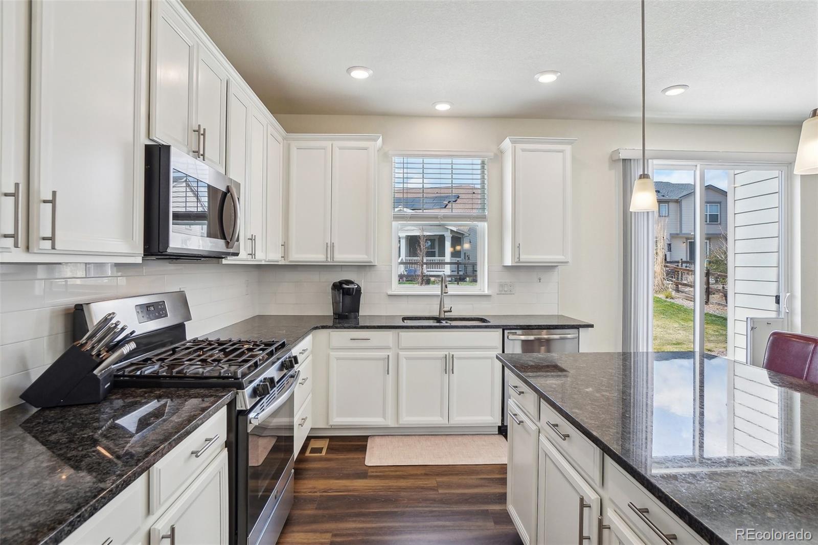 12797 Clearview Street Firestone, CO 80504 - Photo 6 of 44 a kitchen with stainless steel appliances granite countertop a stove a sink and a refrigerator
