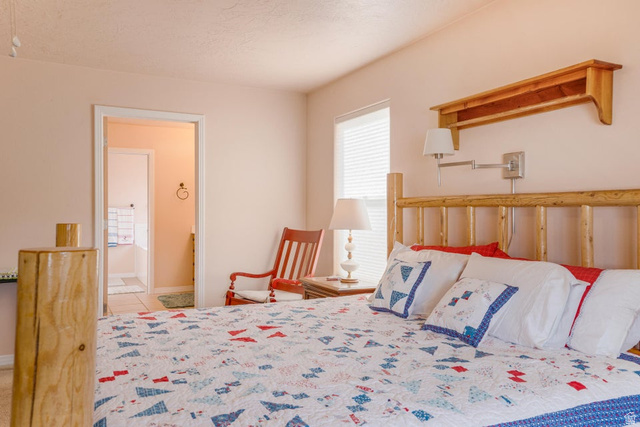 48 South Sage Road Pine Valley, UT 84781 - Photo 25 of 61 Bedroom featuring a log-style bed frame, an integrated wall-mounted swing arm lamp, and a window with blinds