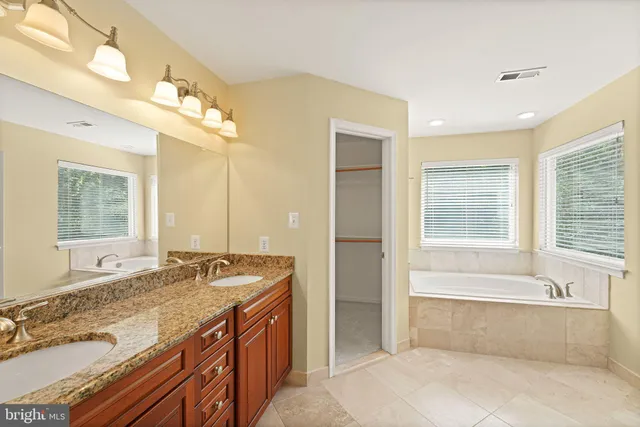 a bathroom with a granite countertop sink mirror and shower