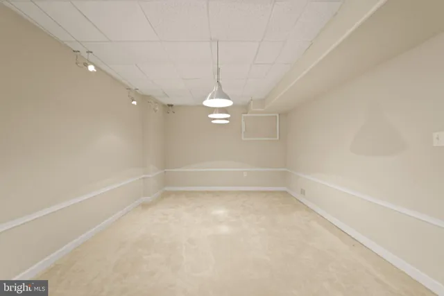 an empty room with a ceiling fan and carpet