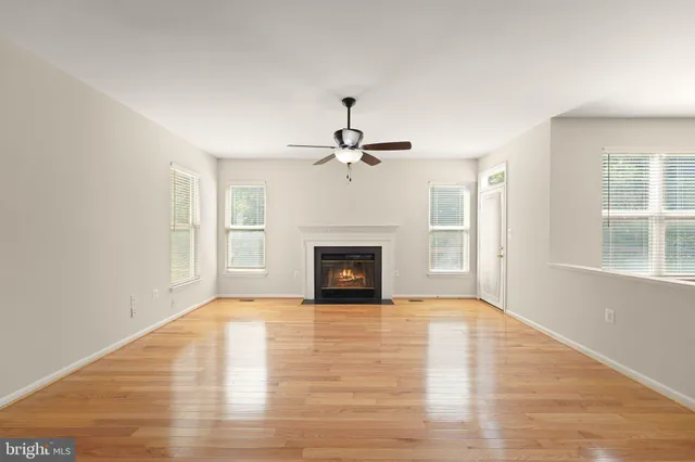 wooden floor fireplace and windows in an empty room
