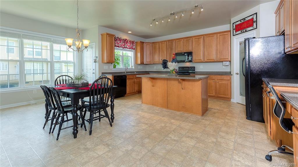 5312 Conant Circle Fort Mill, SC 29708 - Photo 12 of 25 a kitchen with stainless steel appliances granite countertop a dining table chairs and a refrigerator