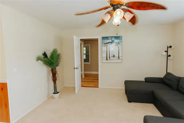 a living room with furniture a window and a potted plant