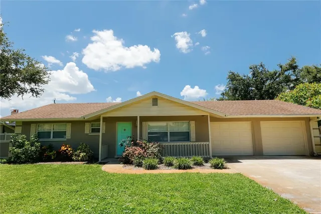 a front view of a house with a garden and yard