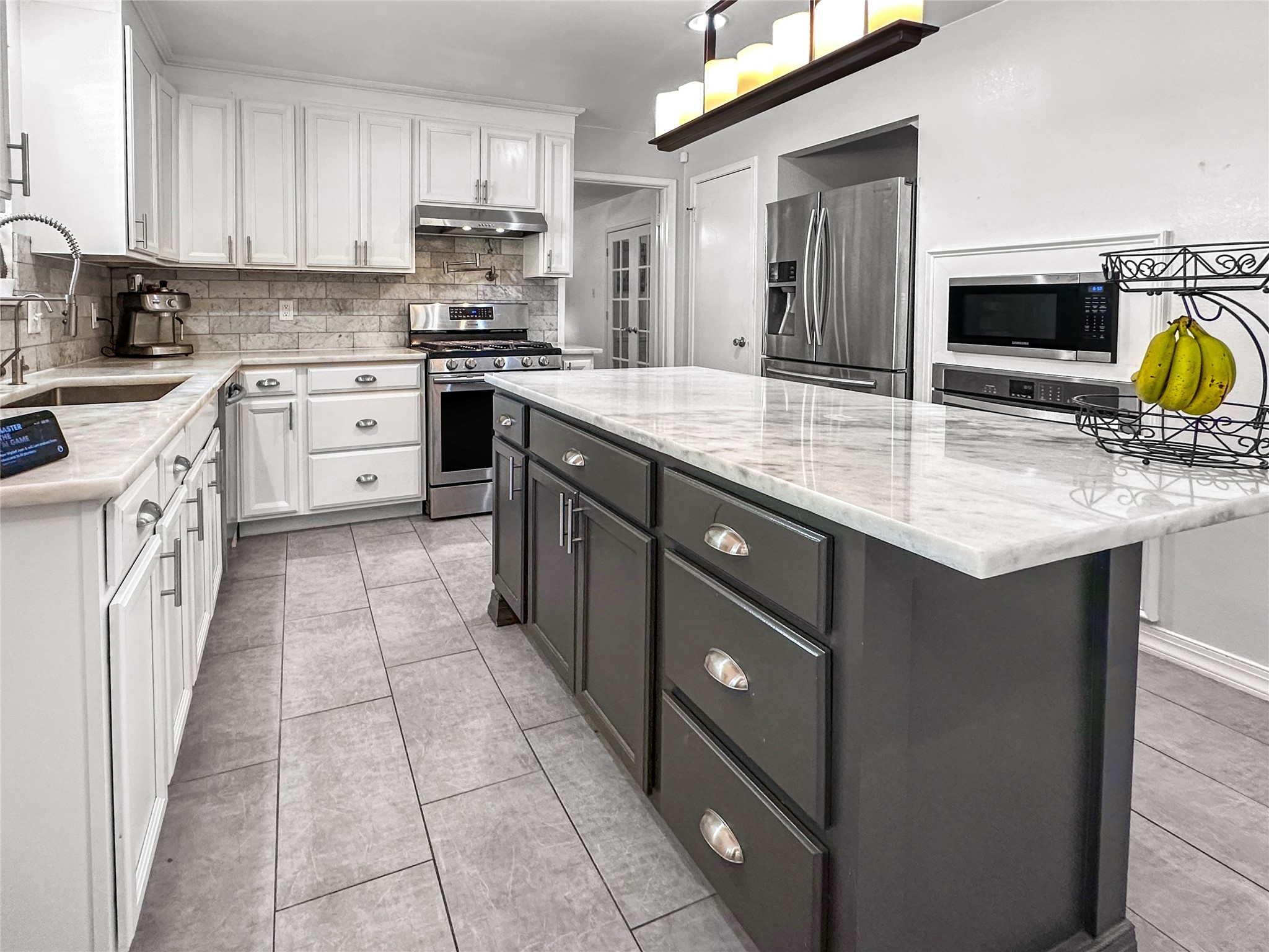 6511 Castle Pine Lane Spring, TX 77379 - Photo 15 of 49 Chef-inspired kitchen featuring stainless steel appliances, a desirable pot filler above the cooktop, and an oversized gas range designed for both functionality and style.