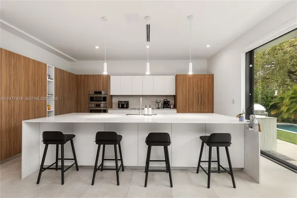a kitchen with a table chairs refrigerator and cabinets