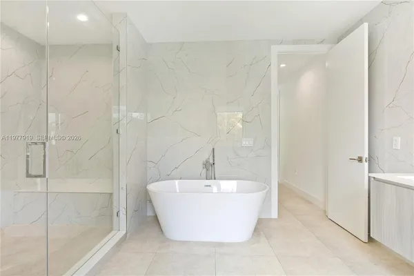 a bathroom with double vanity sink a mirror and a bathtub