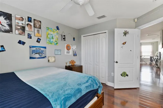a view of a livingroom with wooden floor and a ceiling fan