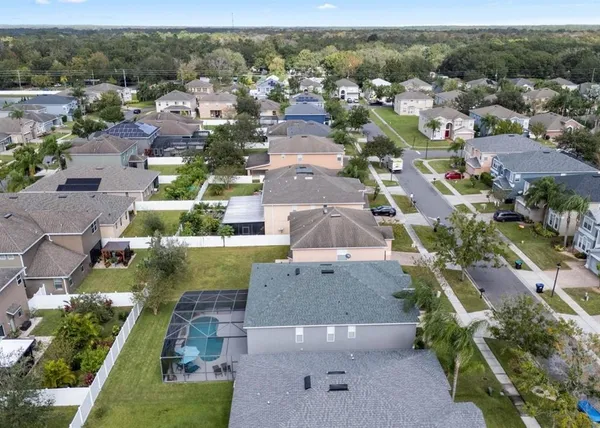 an aerial view of residential houses with outdoor space and parking