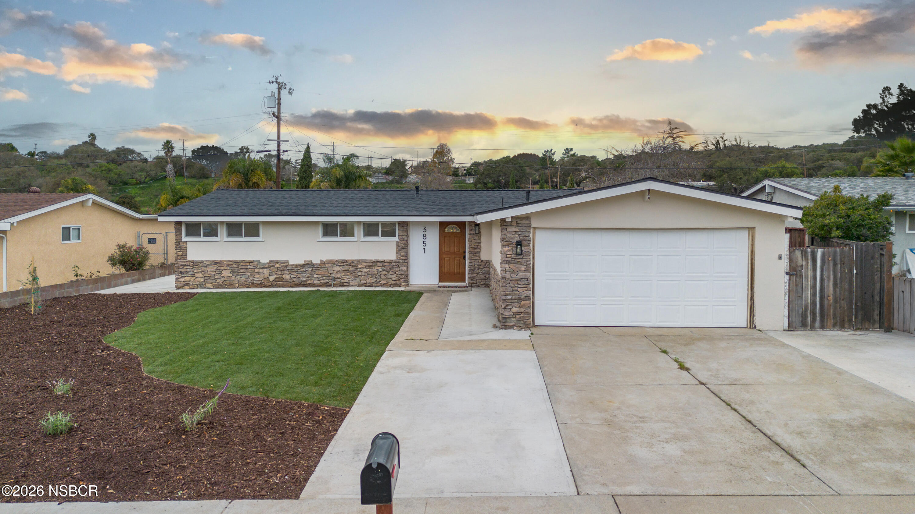 a front view of a house with a garden and yard