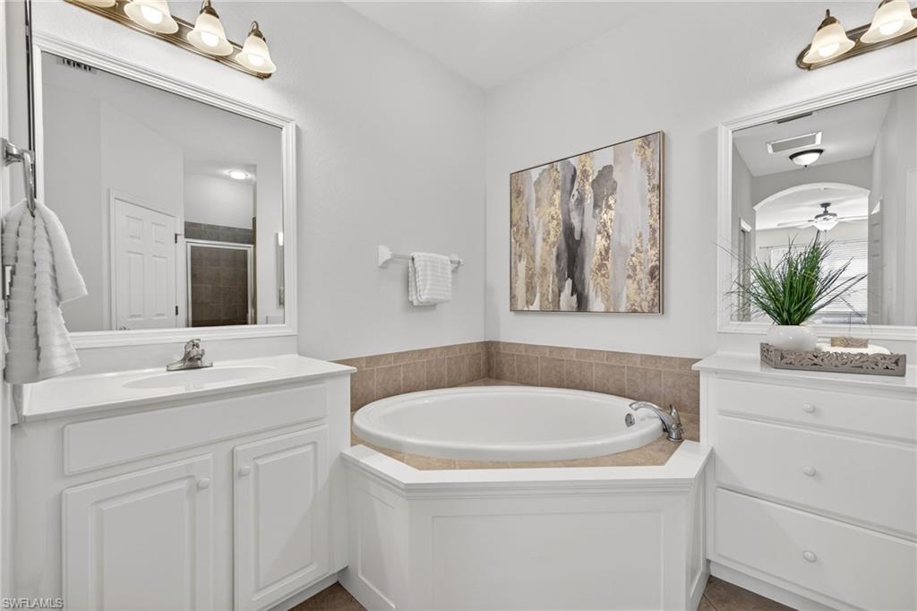 14088 Mirror Court Naples, FL 34114 - Photo 18 of 31 Primary Bathroom featuring a soaking tub, separate shower, double vanities and framed mirrors
