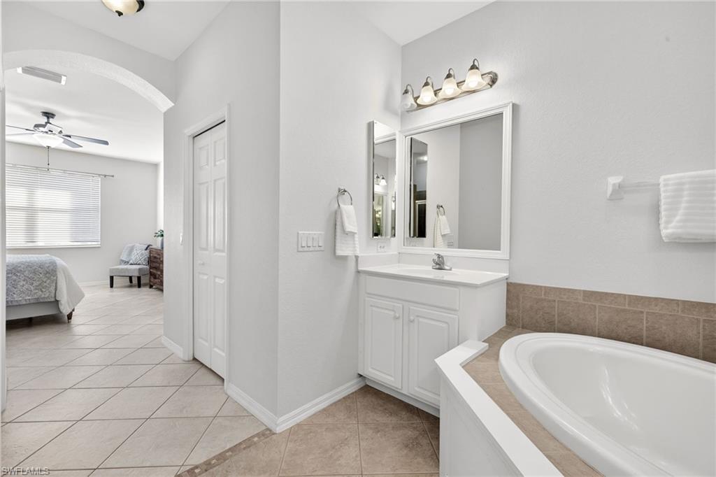 14088 Mirror Court Naples, FL 34114 - Photo 19 of 31 Primary Bathroom with double vanities, soaking tub, light tile patterned floors
