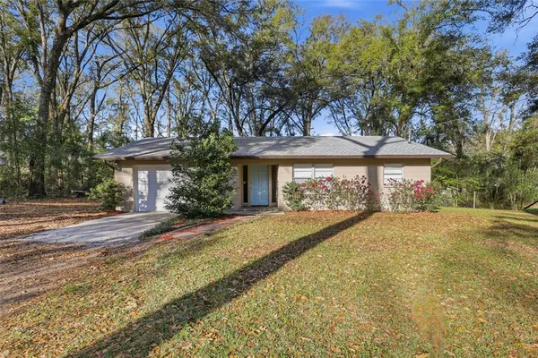 front view of a house with a yard and an trees