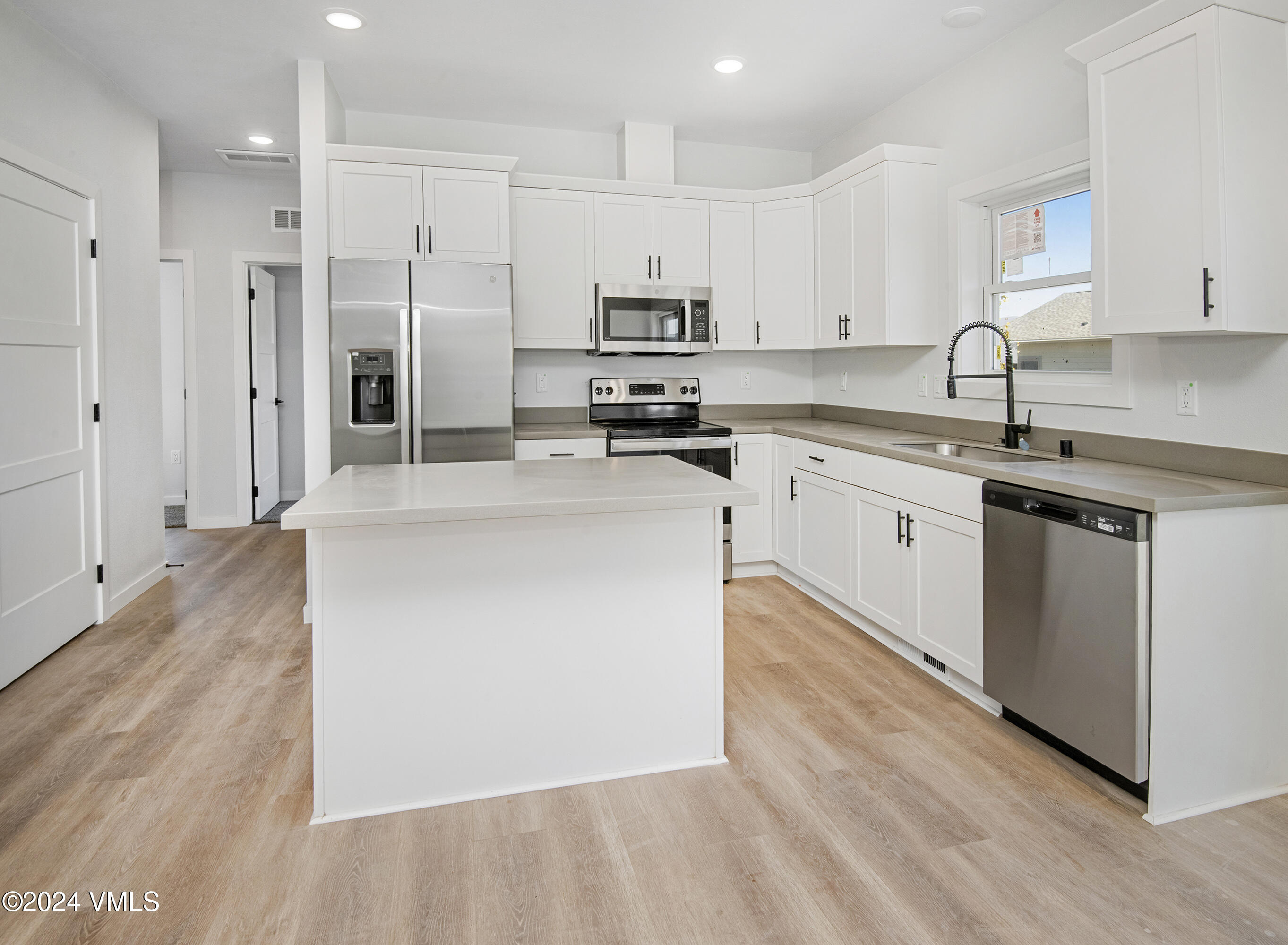 590 Blackhawk Road Gypsum, CO 81637 - Photo 12 of 42 a kitchen with stainless steel appliances granite countertop a stove top oven a sink and white cabinets