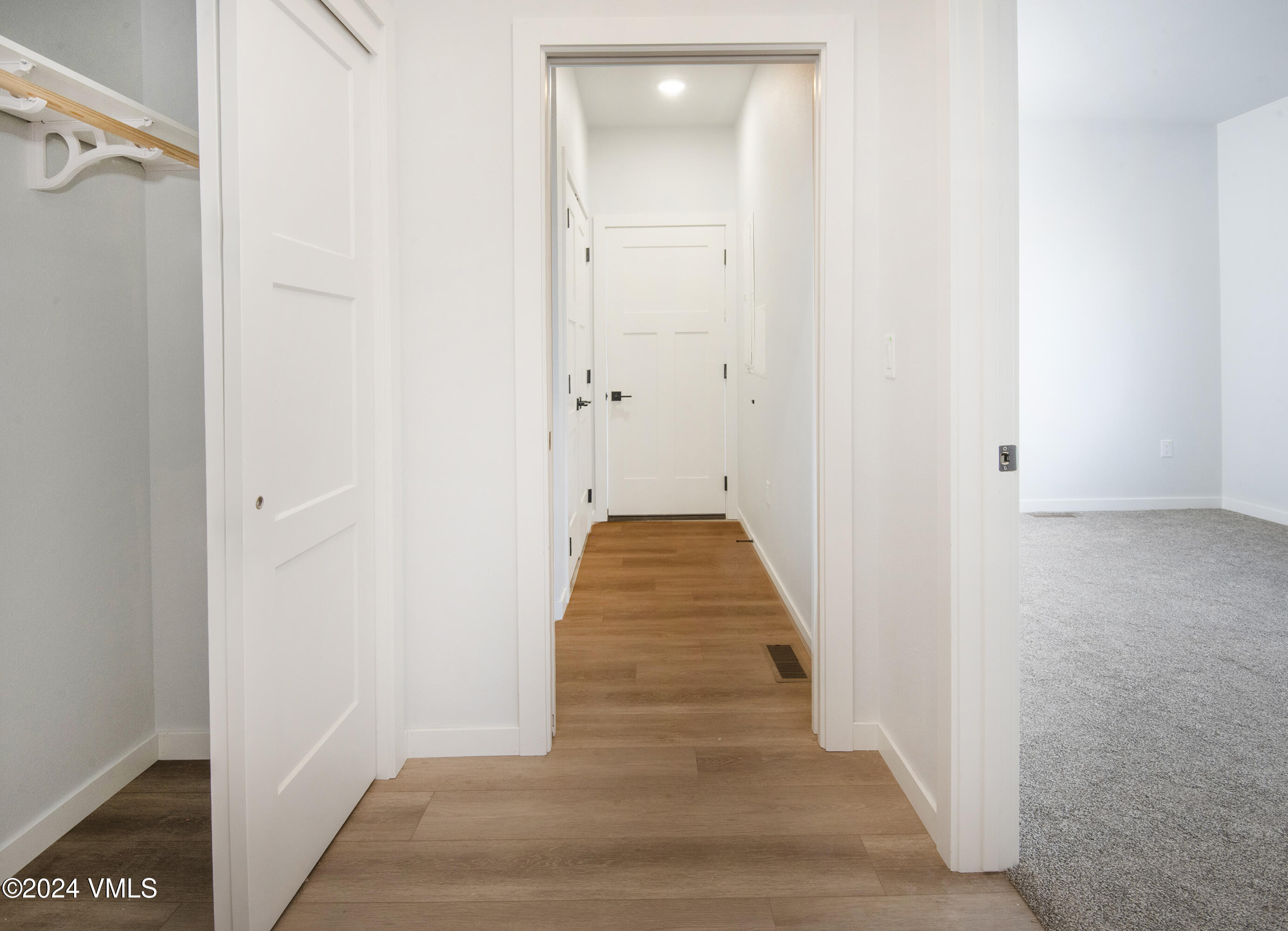 590 Blackhawk Road Gypsum, CO 81637 - Photo 35 of 42 a view of a hallway with wooden floor and a bathroom