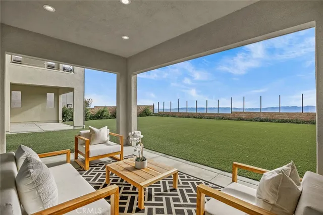 a roof deck with table and chairs and ocean view
