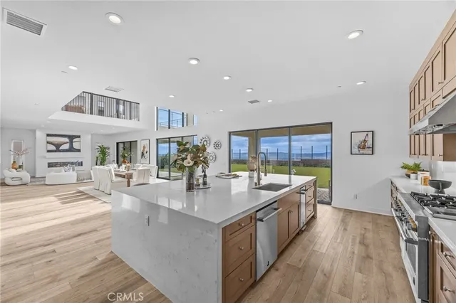 a large kitchen with stainless steel appliances granite countertop a lot of counter space and wooden floor