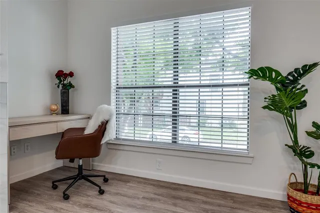 a view of a workspace with furniture and a window