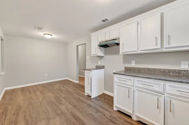 a kitchen with white cabinets and a sink
