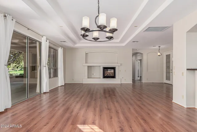 a view of a livingroom with a fireplace a dining table and chairs