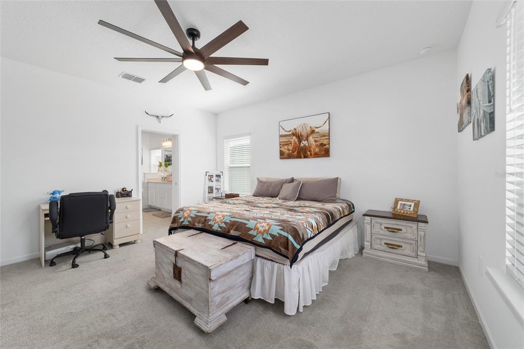4012 Northeast 33rd Avenue Ocala, FL 34479 - Photo 30 of 77 a spacious bedroom with a bed and a ceiling fan
