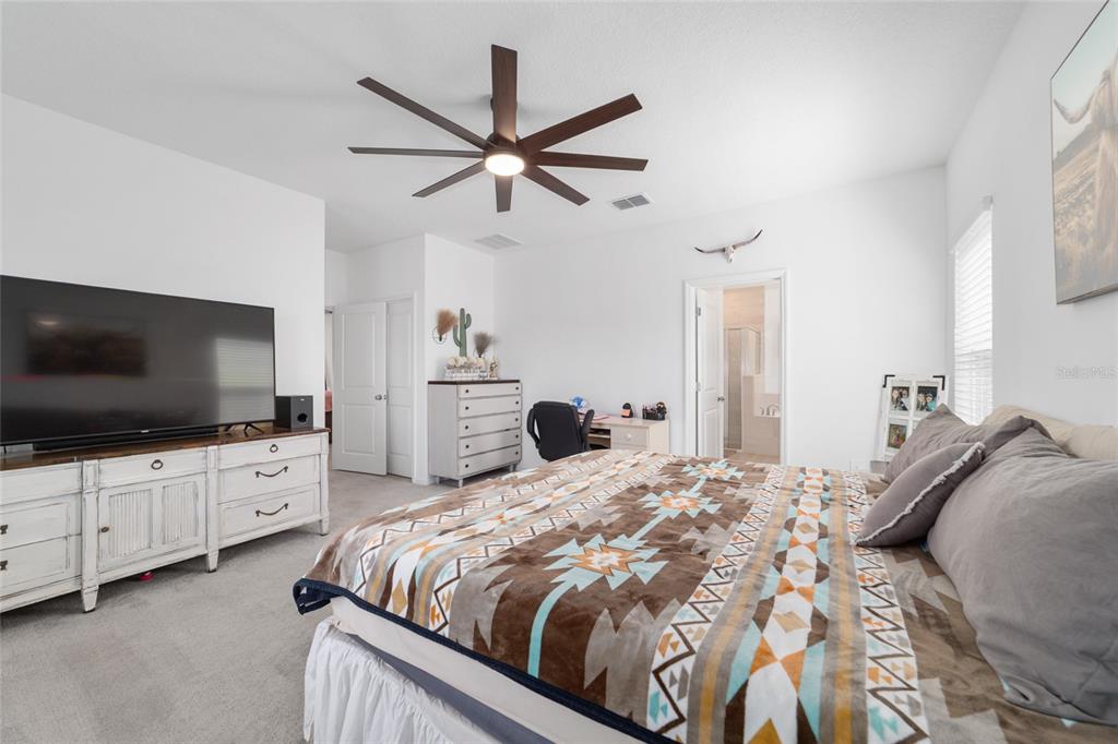 4012 Northeast 33rd Avenue Ocala, FL 34479 - Photo 31 of 77 a bedroom with a large bed and a flat screen tv