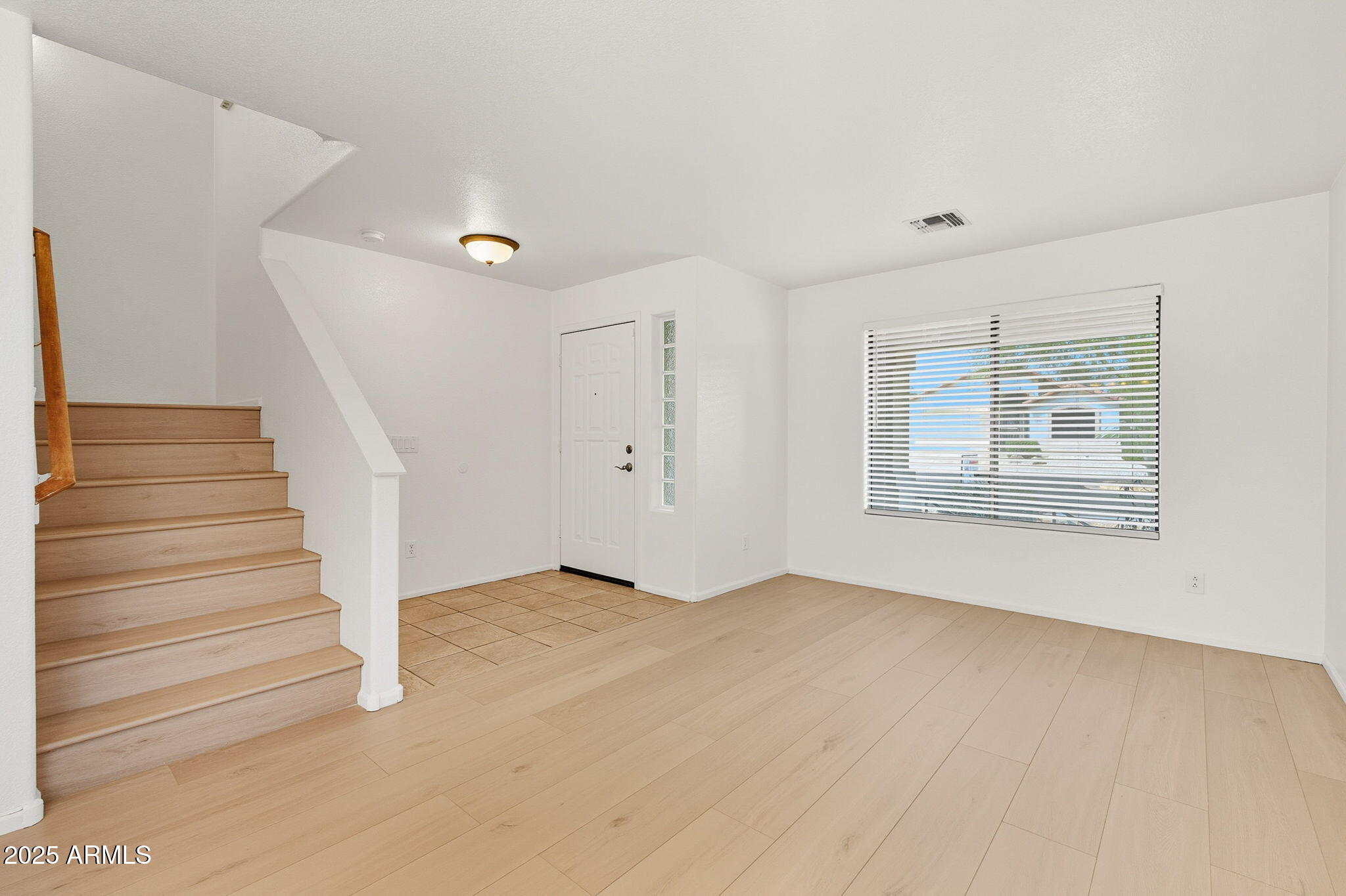 2503 West Gambit Trail Phoenix, AZ 85085 - Photo 8 of 54 a view of an empty room with wooden floor and a window