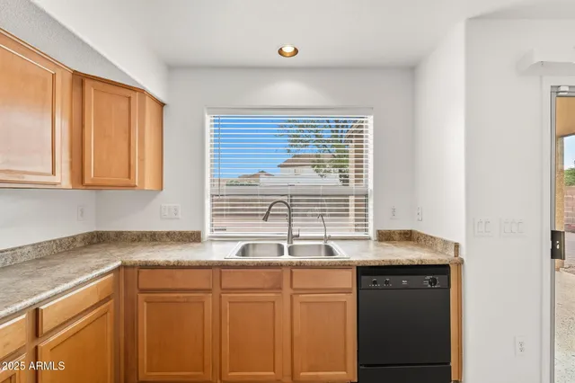 a kitchen with a sink window and cabinets