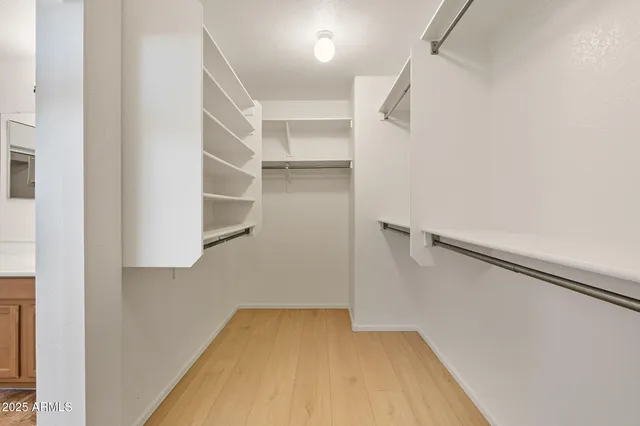 a view of walk in closet with empty racks