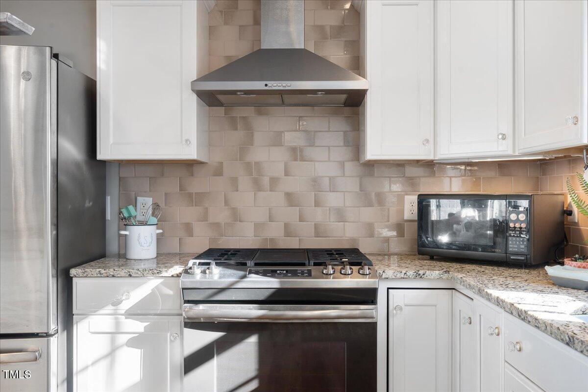 1171 Buck Street Road Roxboro, NC 27574 - Photo 15 of 63 a kitchen with granite countertop a stove and a white cabinets