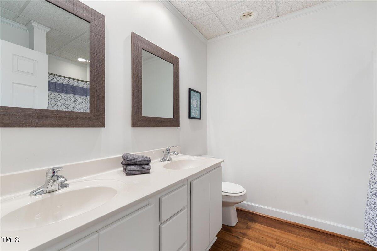 1171 Buck Street Road Roxboro, NC 27574 - Photo 36 of 63 a bathroom with a double vanity sink toilet and mirror