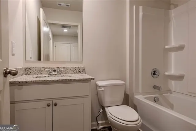 a bathroom with a sink toilet vanity and shower