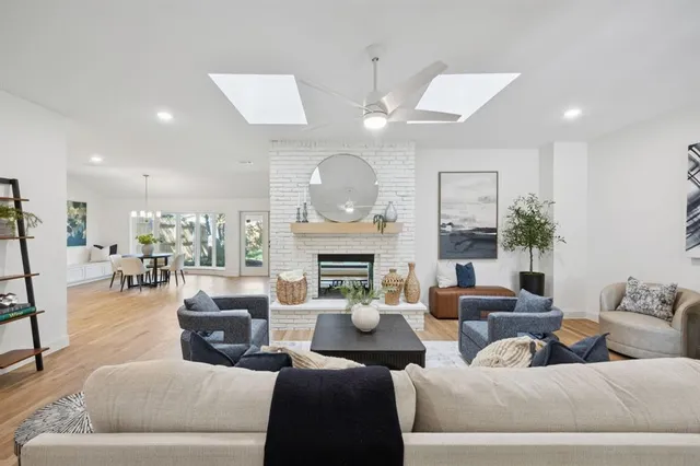 a living room with furniture a fireplace and a chandelier