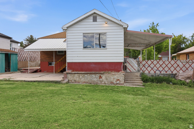 774 37th Street South Ogden, UT 84403 - Photo 28 of 47 Expansive rear yard featuring a manicured lawn, concrete patio, and a covered carport with a metal roof