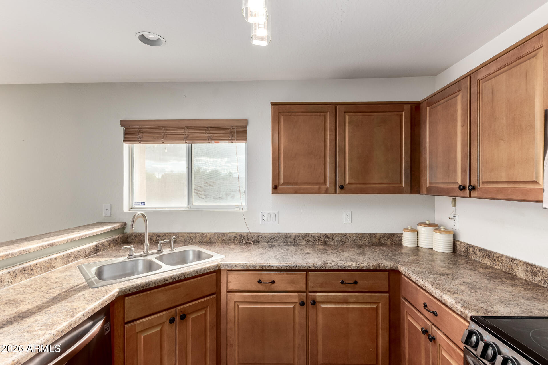 1491 East Rolls Road San Tan Valley, AZ 85143 - Photo 11 of 35 a kitchen with stainless steel appliances granite countertop a sink stove and cabinets