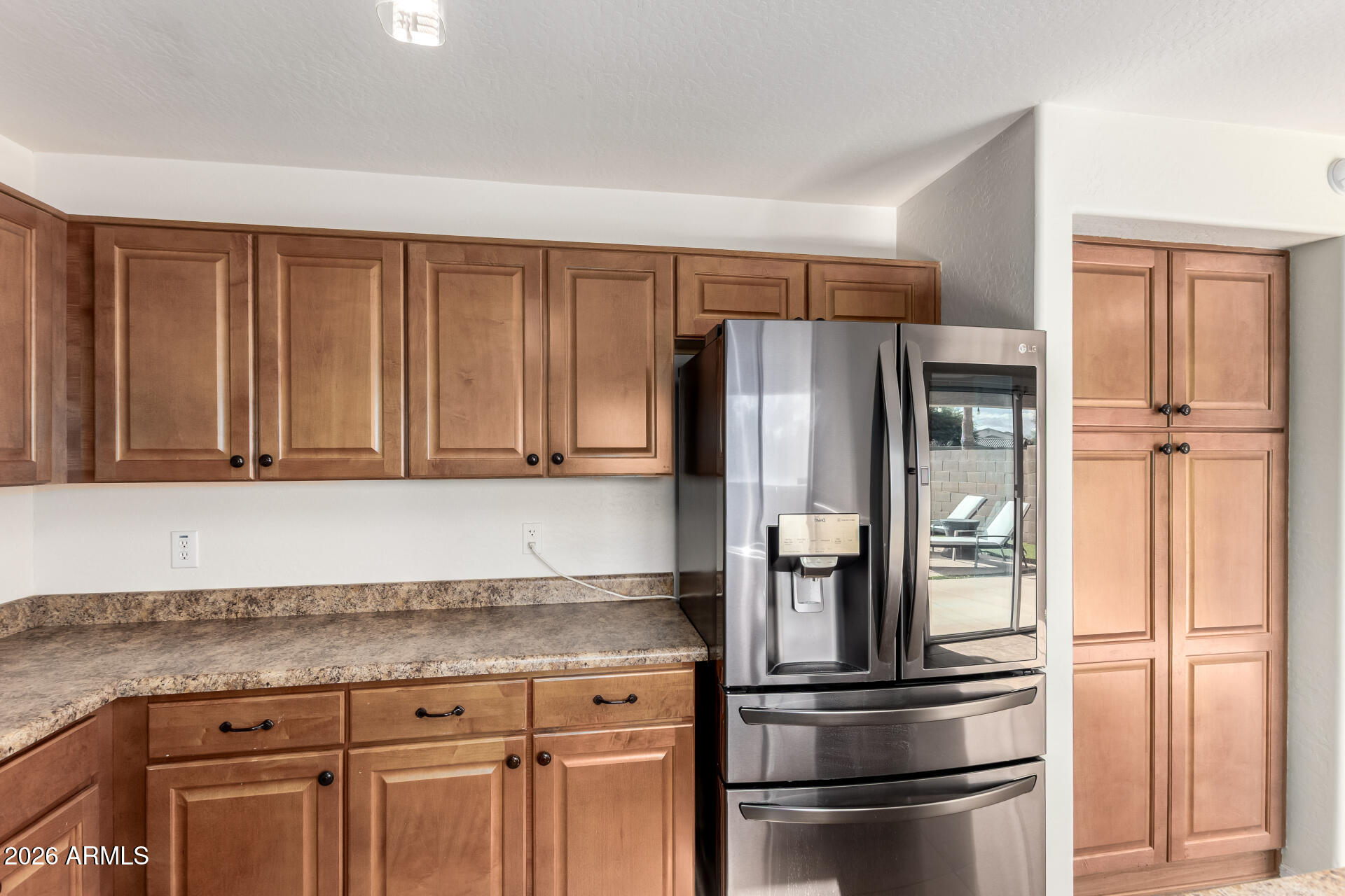 1491 East Rolls Road San Tan Valley, AZ 85143 - Photo 12 of 35 a kitchen with granite countertop stainless steel appliances and refrigerator
