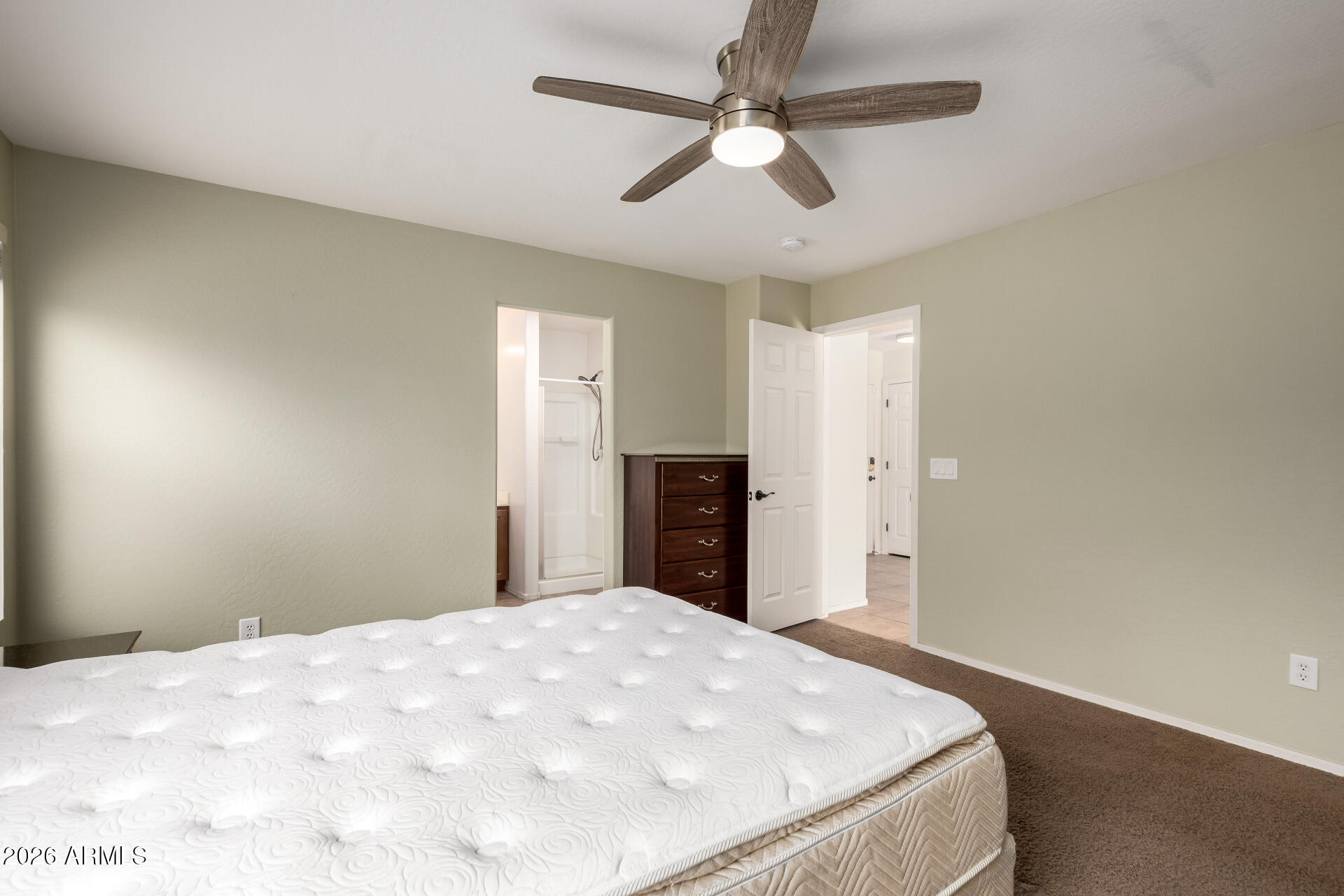 1491 East Rolls Road San Tan Valley, AZ 85143 - Photo 17 of 35 a bedroom with a large bed and a chandelier