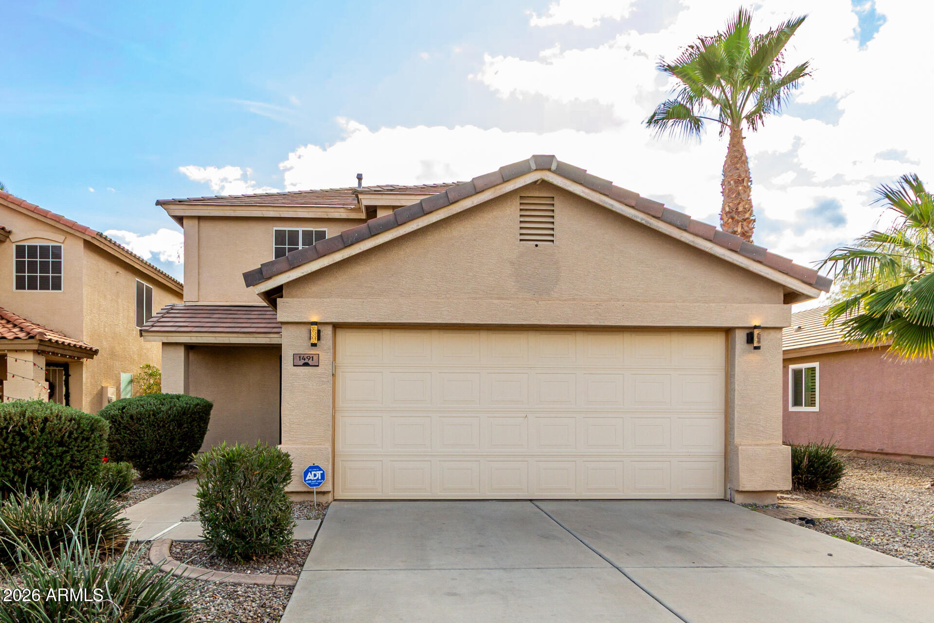 1491 East Rolls Road San Tan Valley, AZ 85143 - Photo 2 of 35 a front view of a house with a garage