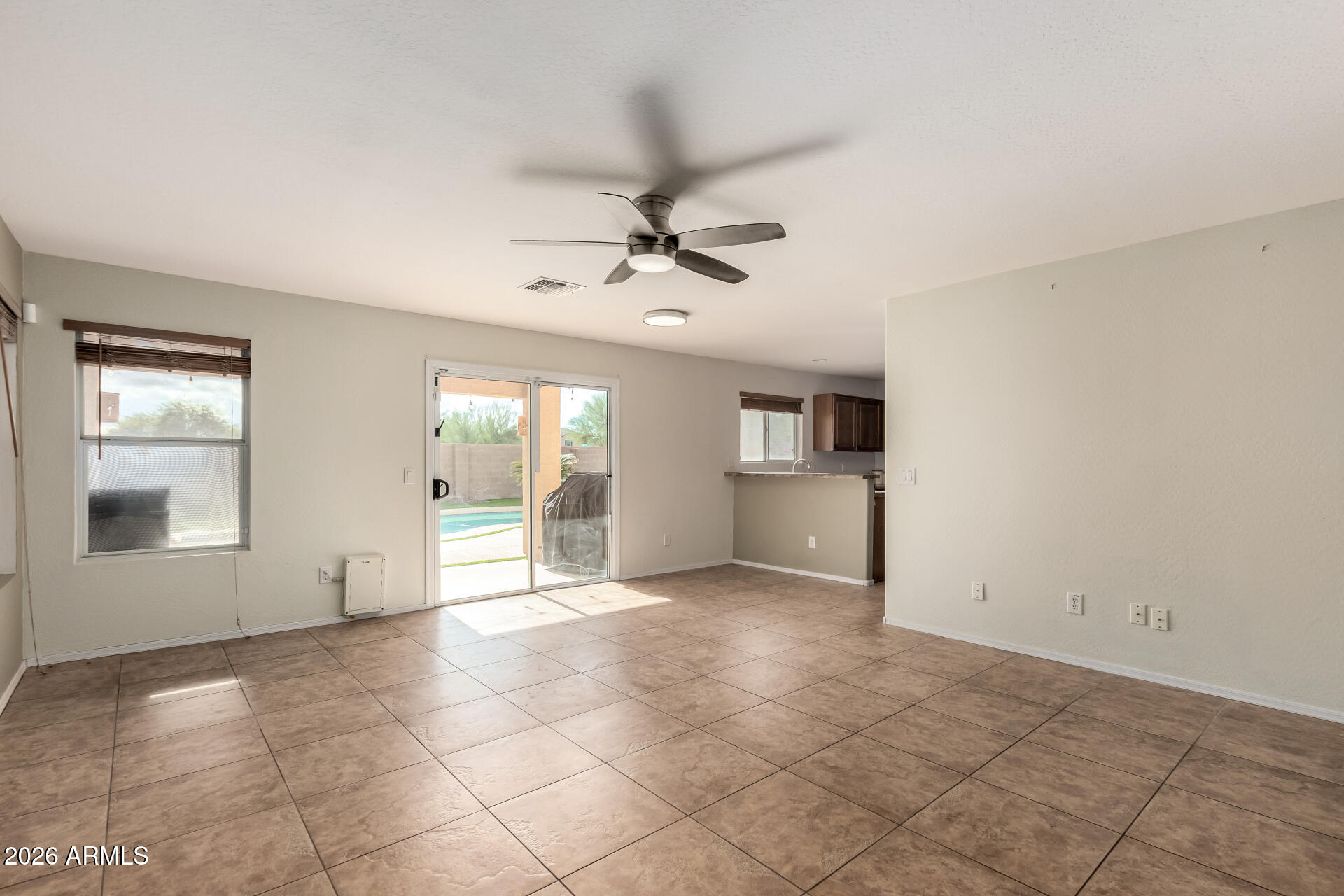 1491 East Rolls Road San Tan Valley, AZ 85143 - Photo 7 of 35 an empty room with chandelier fan and windows
