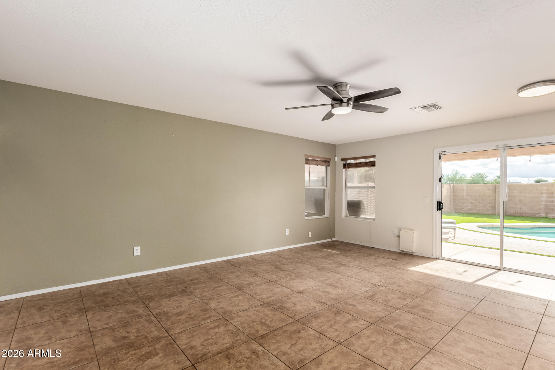 1491 East Rolls Road San Tan Valley, AZ 85143 - Photo 8 of 35 an empty room with windows and ceiling fan