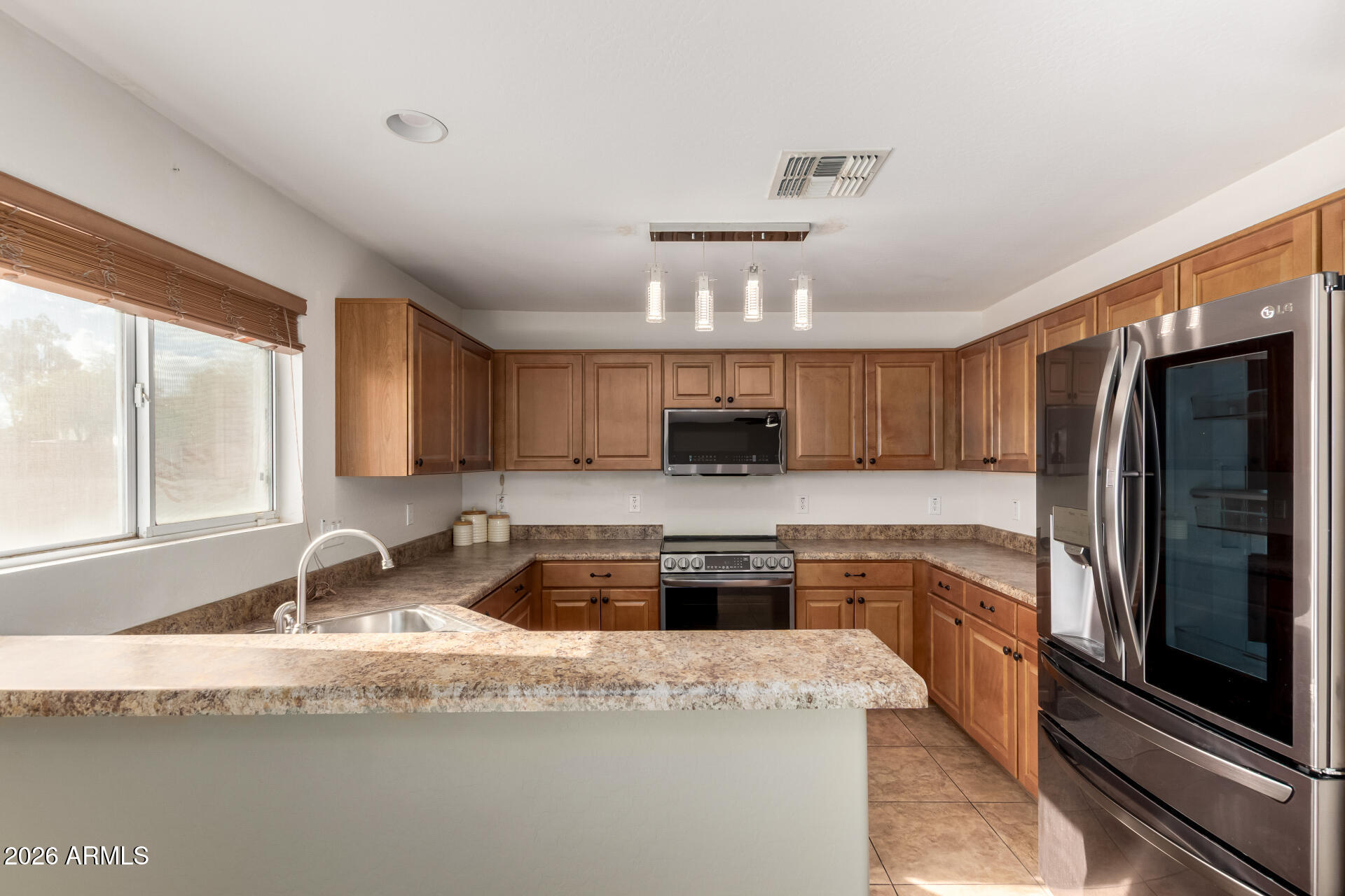 1491 East Rolls Road San Tan Valley, AZ 85143 - Photo 10 of 35 a kitchen with granite countertop a sink stainless steel appliances and cabinets