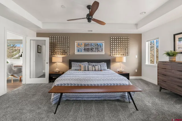 a bedroom with a bed a window and potted plant