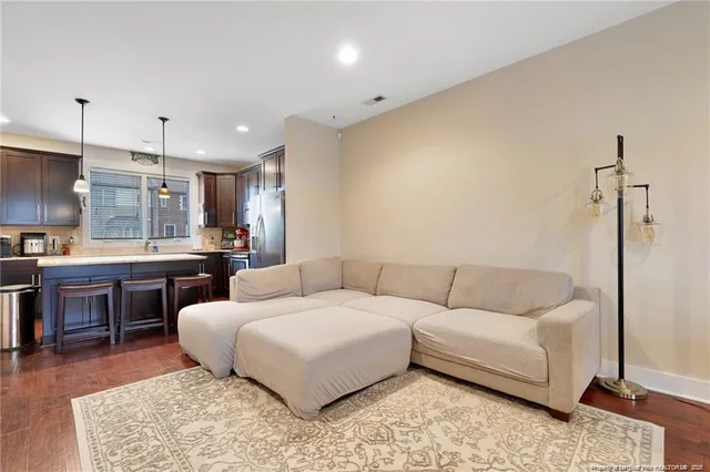 a living room with a couch and a kitchen view