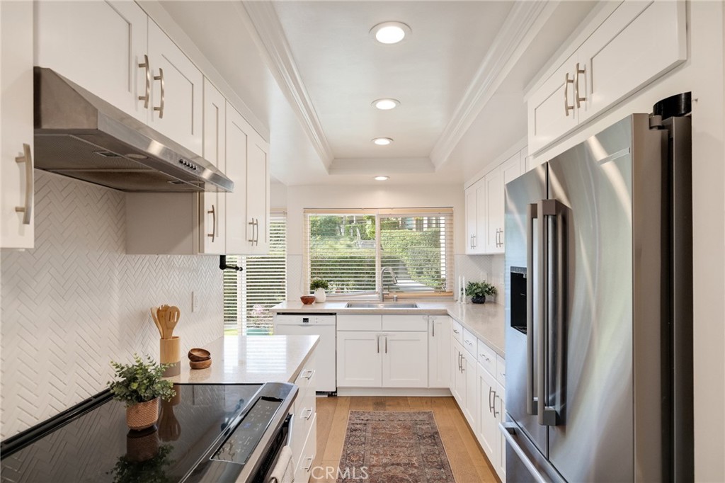 58 Hilltop Circle Rancho Palos Verdes, CA 90275 - Photo 21 of 51 a kitchen with stainless steel appliances a refrigerator a sink a stove and white cabinets with wooden floor