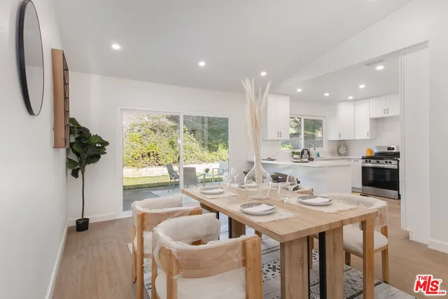 a kitchen with a sink a counter top space and living room view