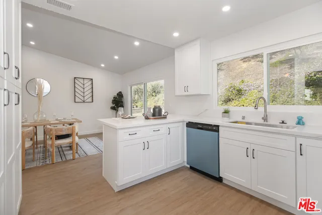 a kitchen with a sink cabinets and wooden floor